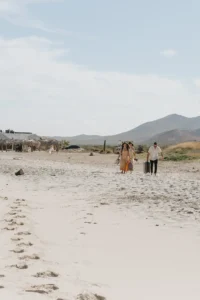bride's friends walking to the beach to celebrate an elopement.
