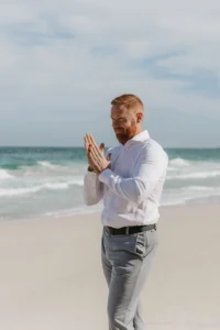 groom standing at the beach waiting for the bride, being the blue beach and surrounded by mountains. 