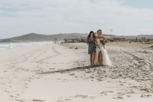 bride and her friend walking to the beach for her elopement.
