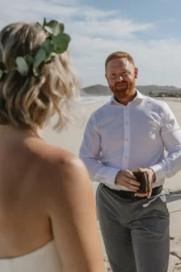 groom reading vows to the bride at the beach. 