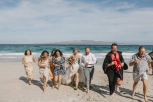couple and guest running celebrating after their elopement. 