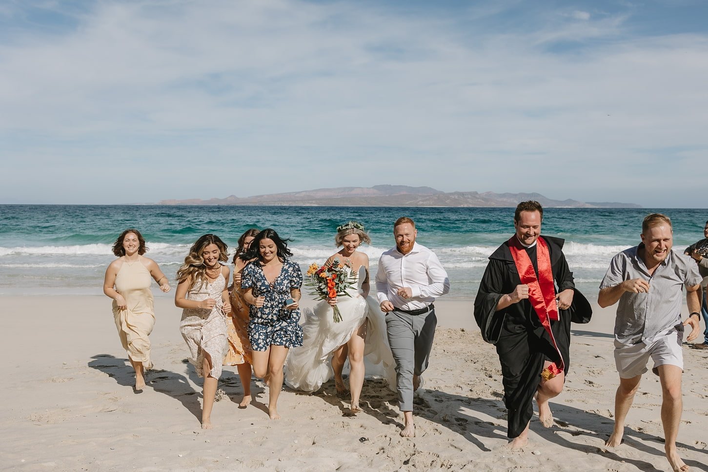 couple and guest running celebrating after their elopement.