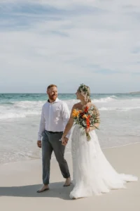 couple walking holding hands at Tecolote beach.