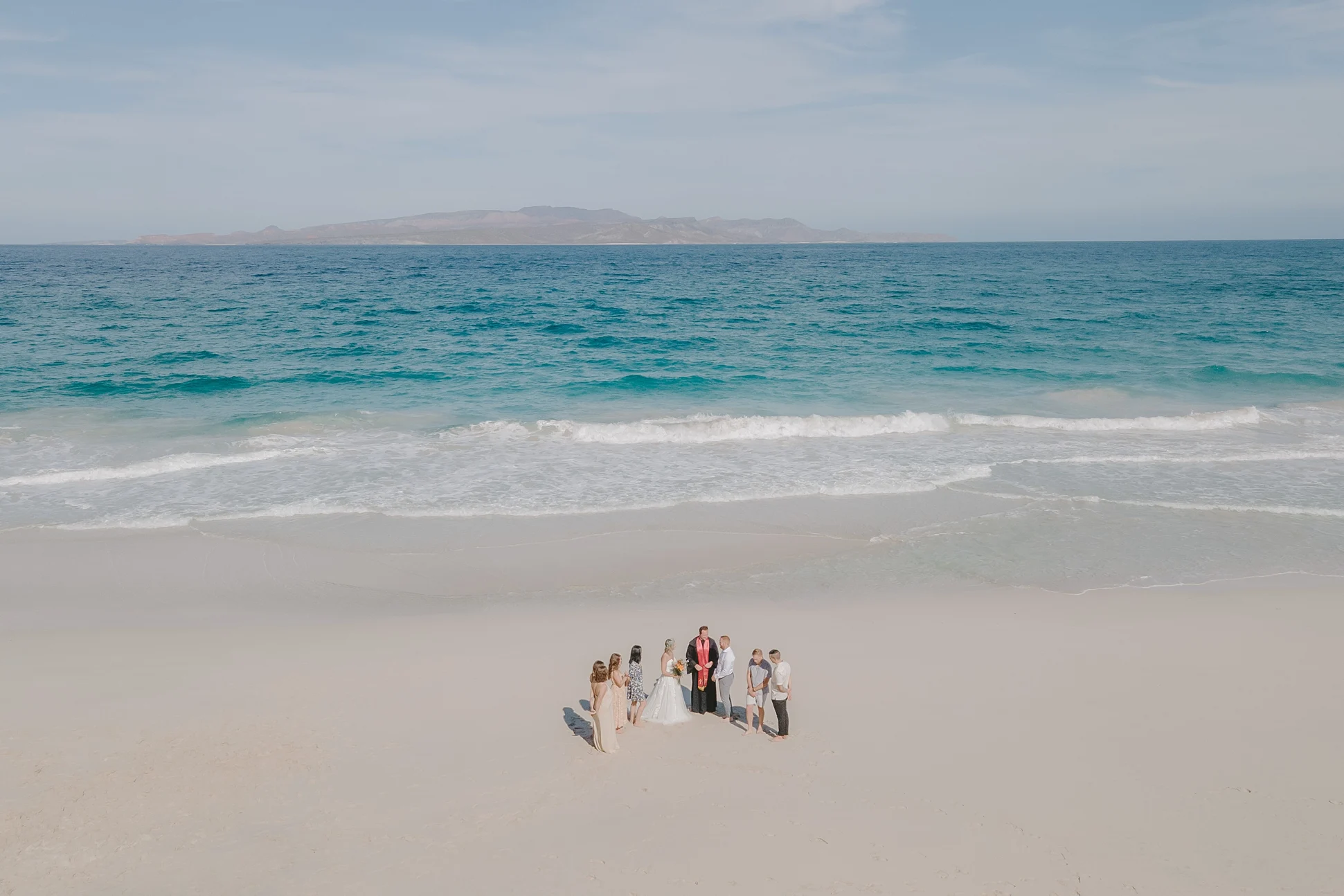 drone photo of a couple and their closest friends eloping in a tecolote beach. 