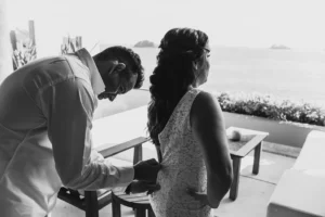 groom helping the bride get her dress on.