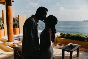 couple kissing at the balcony of their resort in Ixtapa Mexico.