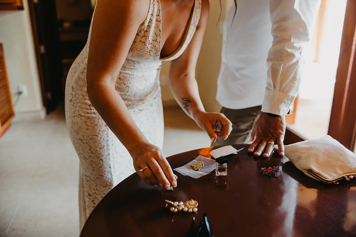 bride getting her accessories together is a detail photo inside their room. 