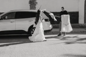 bride and groom getting their stuff ready at their car to head over to the beach.