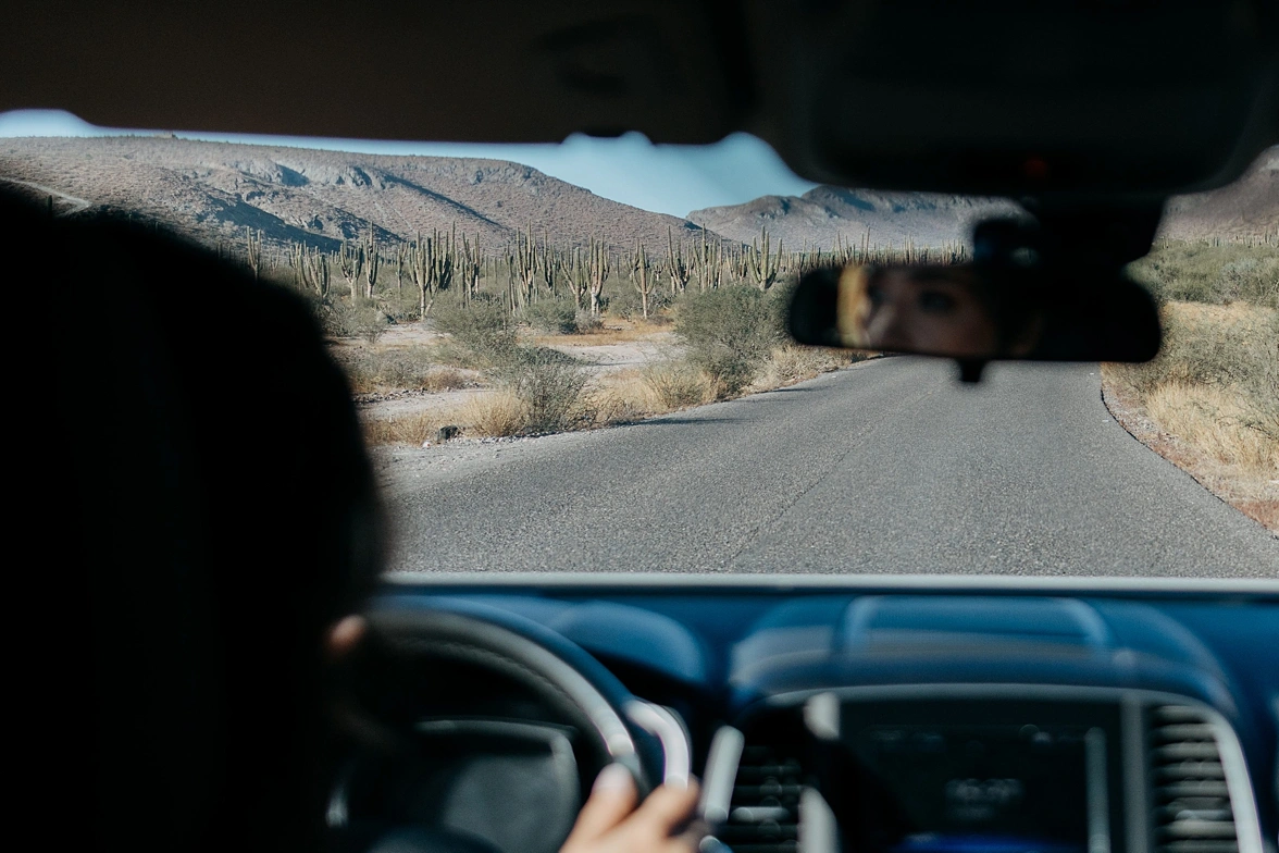 bride and groom driving to Balandra beach, the landscapes full of cactus and mountains. 